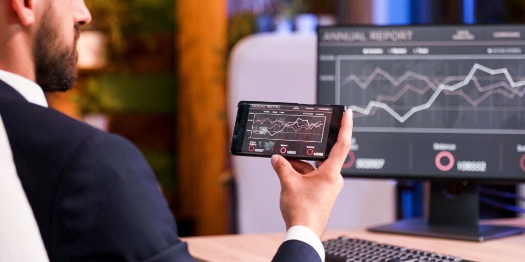 Pessoa usando plataforma de investimentos no notebook com gráficos simples — foco em usabilidade para iniciantes